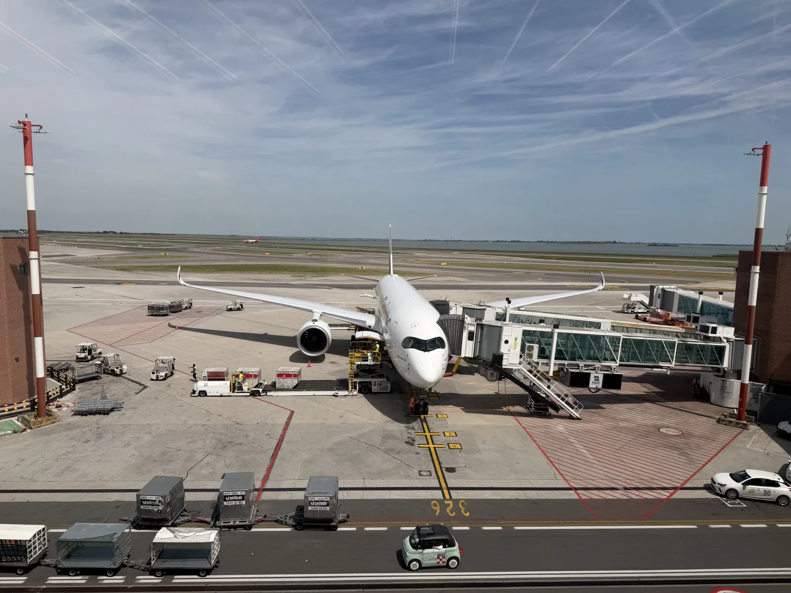 An Airbus A350 at the gate, nose facing the camera