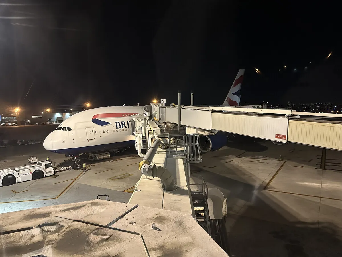 British Airways Airbus A380 at a night gate served by multiple jet bridges